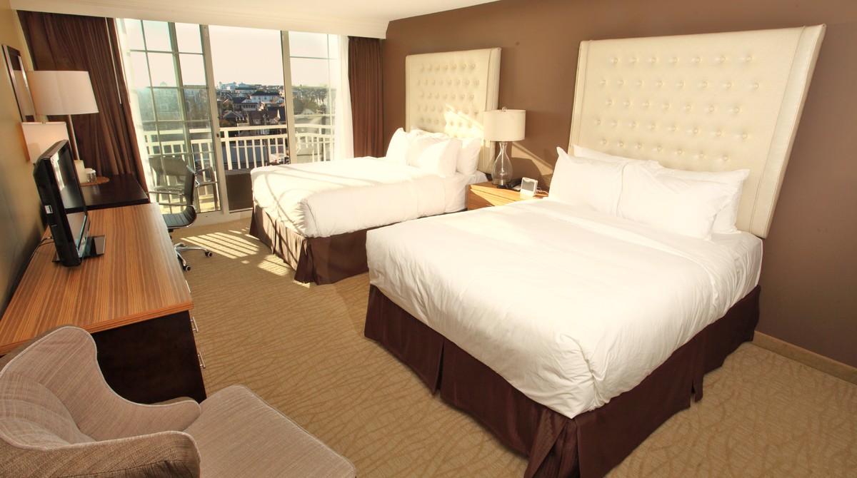 Two queen beds in room with side view of ocean