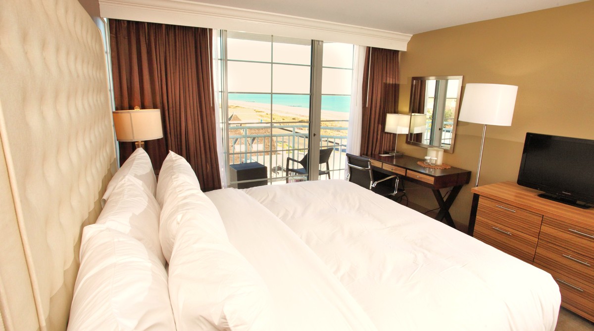 Single king bed in room with side view of ocean