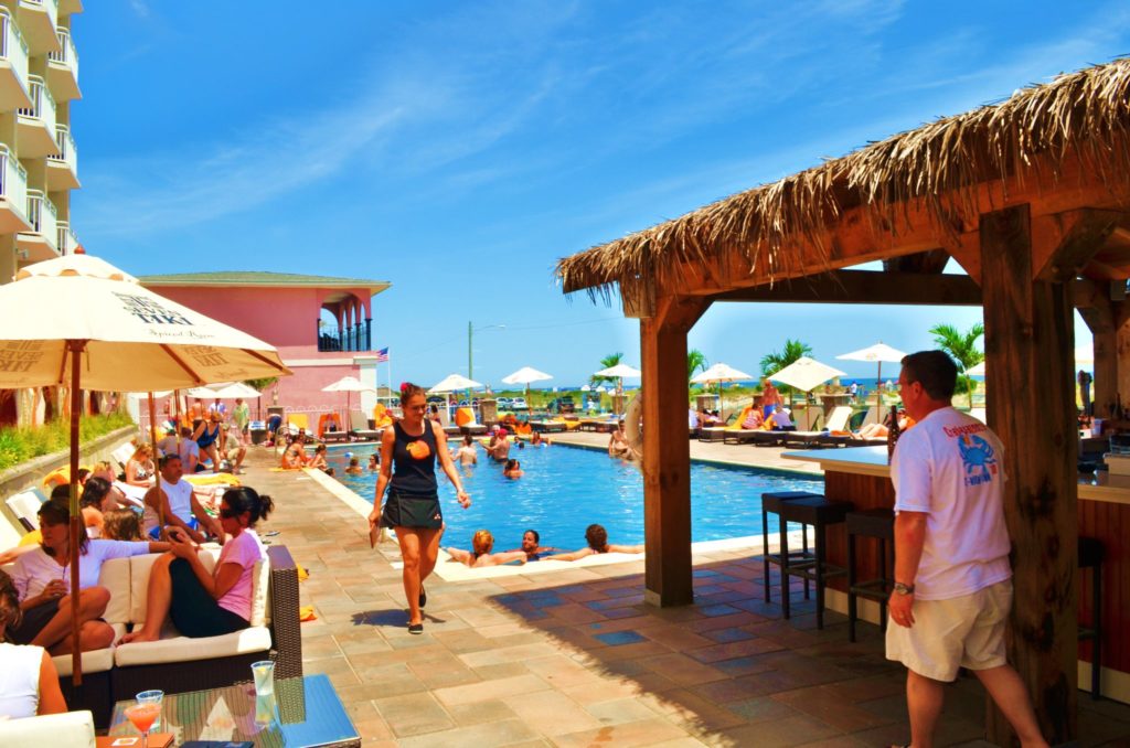 Ocean Club Hotel's Outdoor Tiki Ten35 bar with pool in backdrop
