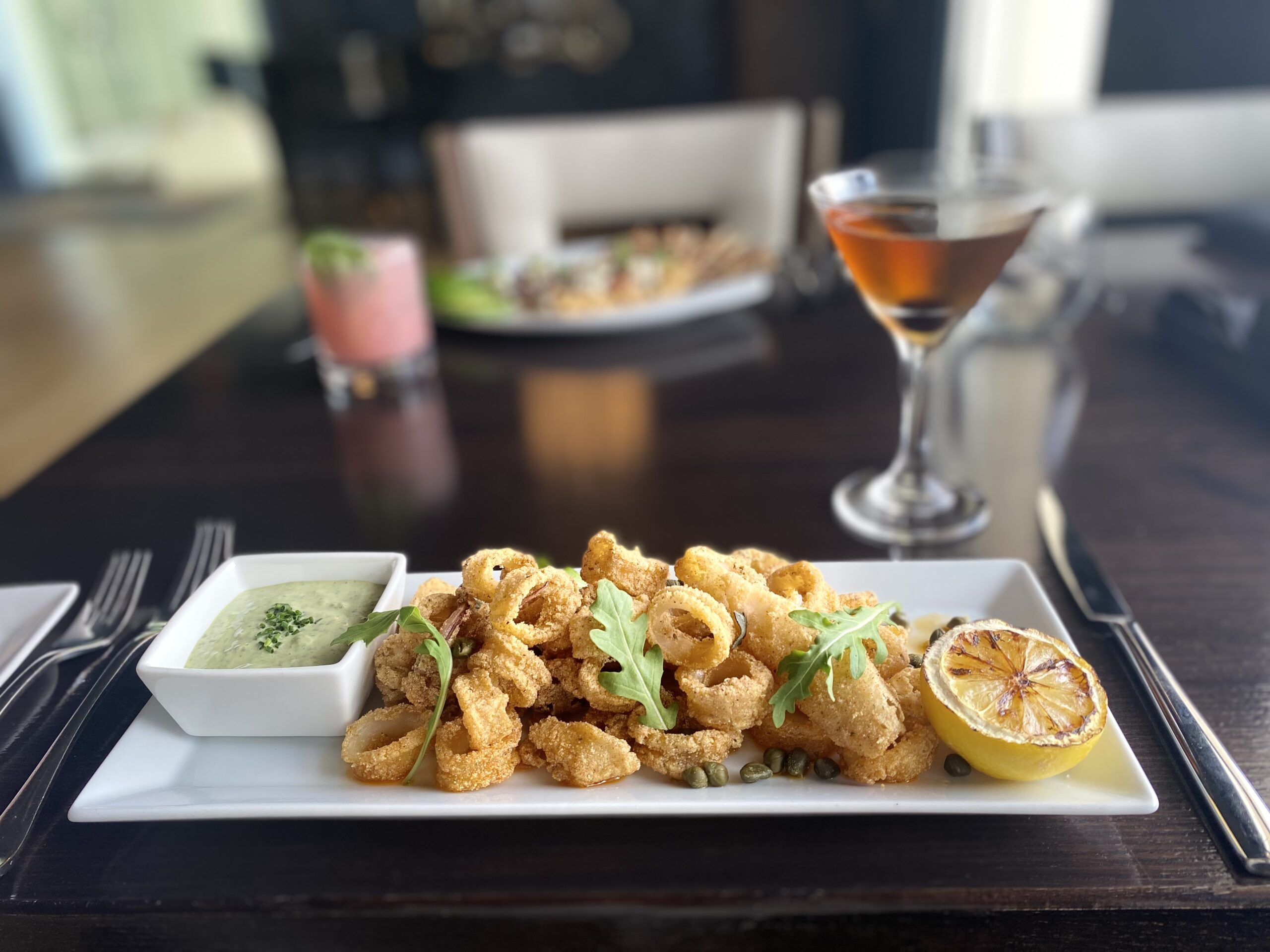 Calamari on rectangular dish in foreground with cocktail in background
The best chef in Cape May finds the best home at the Ocean Club Hotel and SeaSalt Restaurant in Cape May NJ