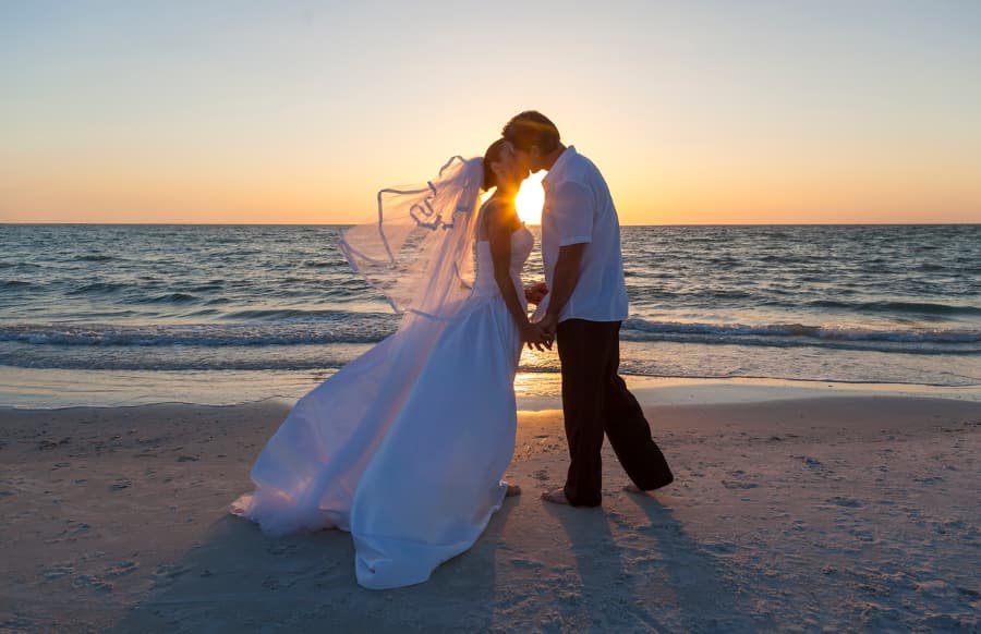 Newlyweds share kiss along the Jersey Shore coastline at sunset