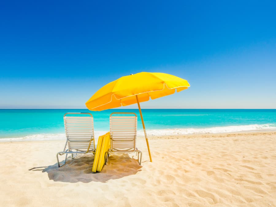 Umbrella and lounge chairs on sandy beach