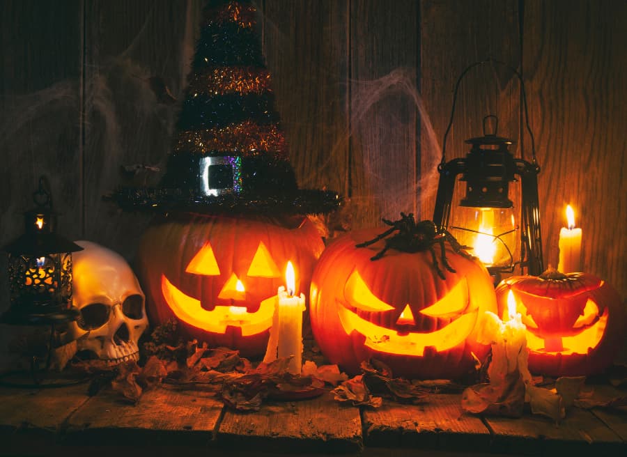 jack-o'-lanterns sitting next to skull and candles