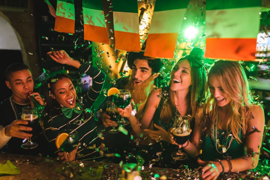 Group of happy friends celebrating and having fun at Saint Patrick’s Day party