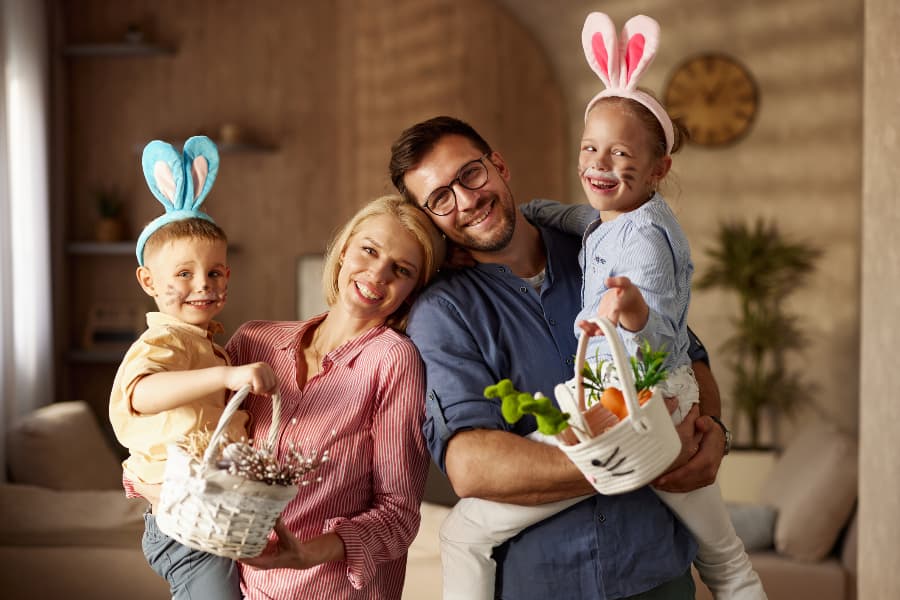 Happy parents holding their children while celebrating Easter