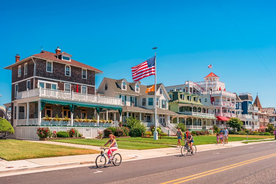 People riding bikes on colorful street in Cape May, NJ