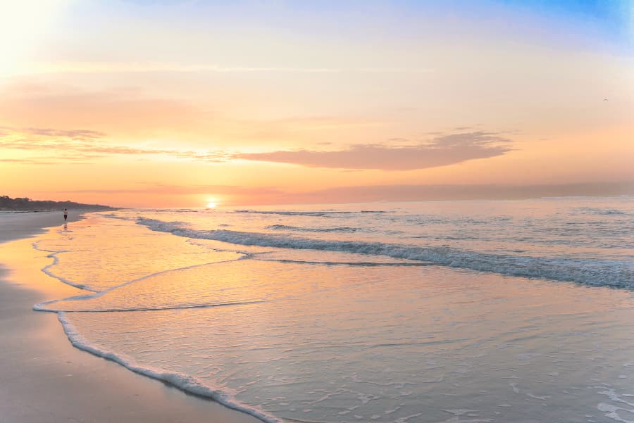 Sunrise over sandy beach with calm waves